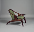 Modern chair with wooden frame and green cushions on a gray background