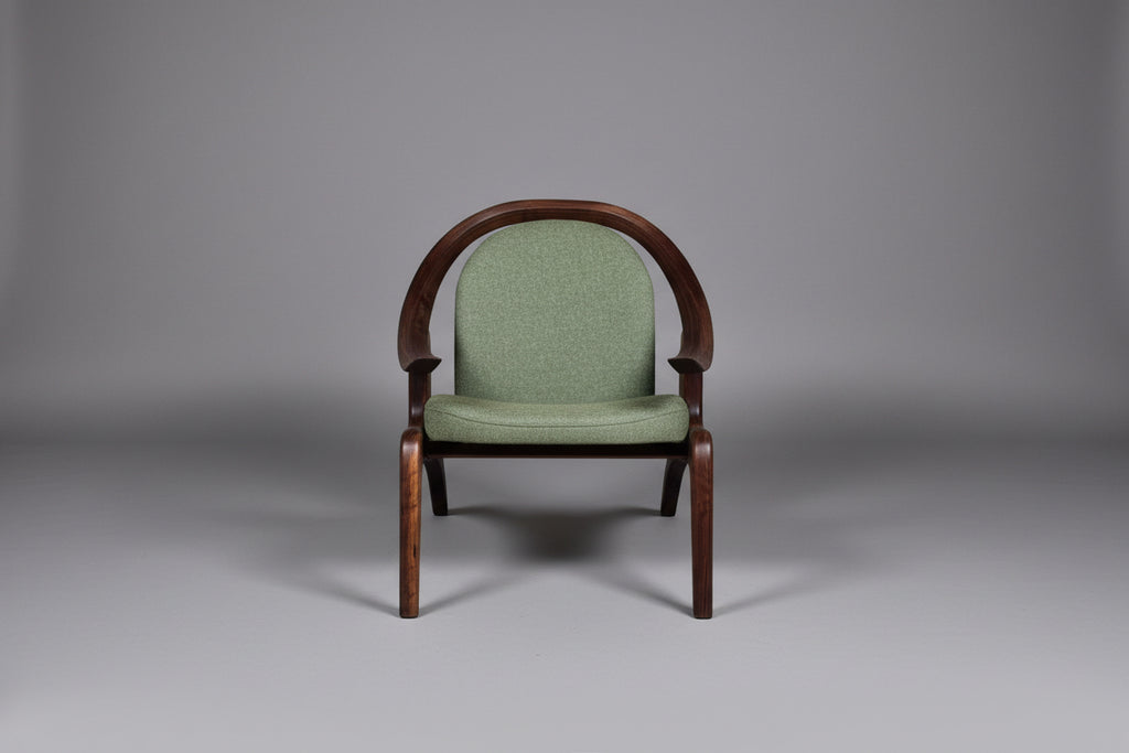 Green upholstered chair with wooden frame on a gray background