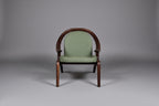 Green upholstered chair with wooden frame on a gray background