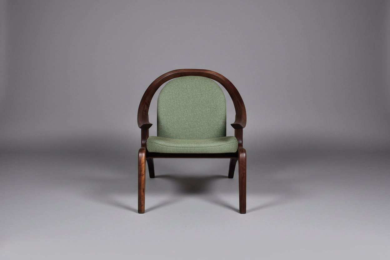 Green upholstered chair with wooden frame on a gray background