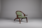 Green armchair with wooden frame on a gray background