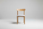 Wooden chair with a white cushion on a gray background