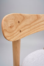 Close-up of a wooden chair arm with a gray background