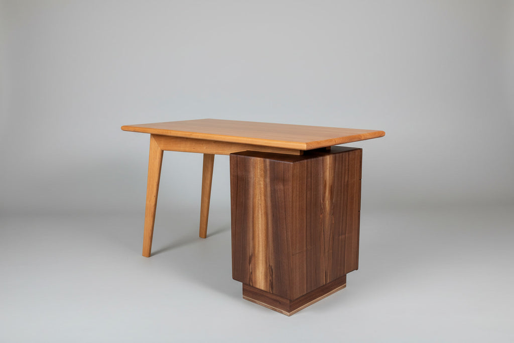 Wooden desk with a rectangular top and cylindrical base on a plain background