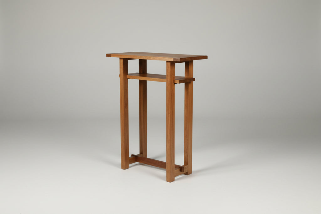 Wooden console table with decorative items against a white wall.