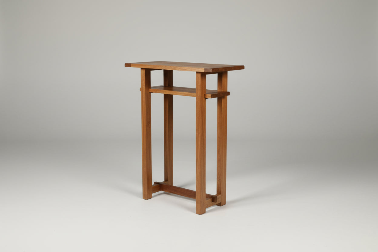 Wooden console table with decorative items against a white wall.